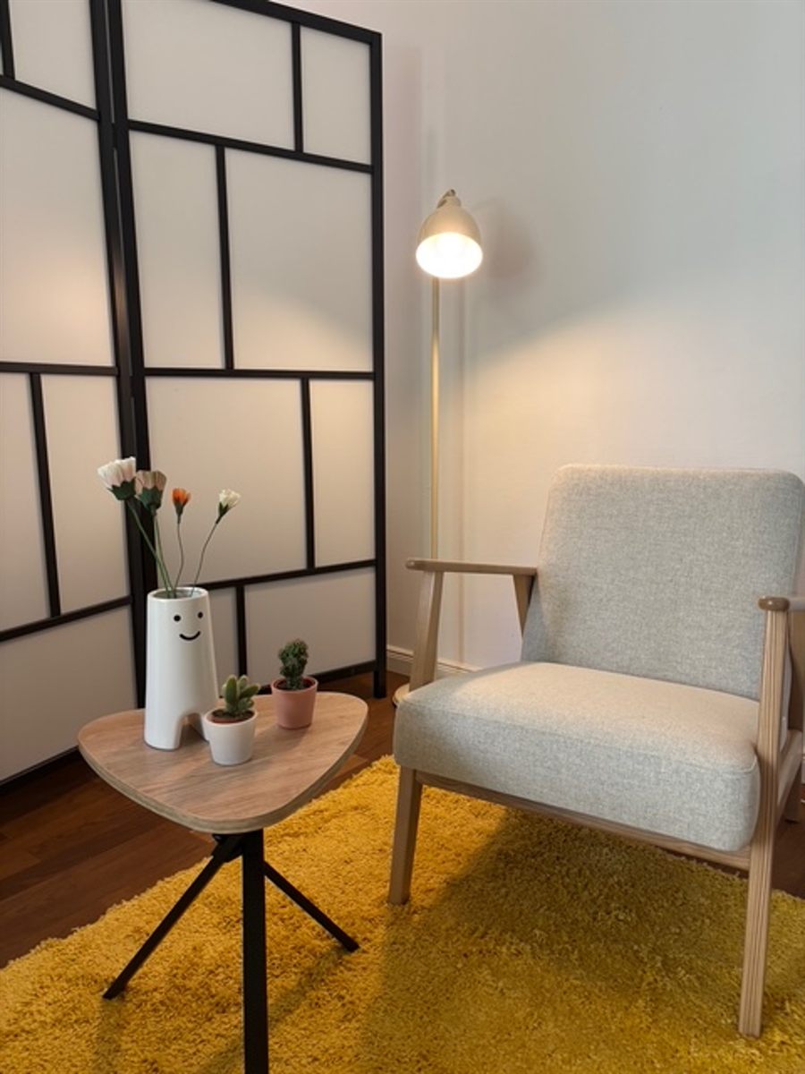 Sessel mit Beistelltisch, Blumen und Stehlampe im Beratungsraum